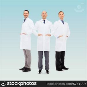 healthcare, profession and medicine concept - smiling male doctors in white coats over blue background