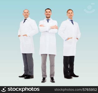 healthcare, profession and medicine concept - smiling male doctors in white coats over blue background