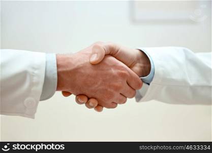 healthcare, profession, people and medicine concept - close up of doctors hands making handshake