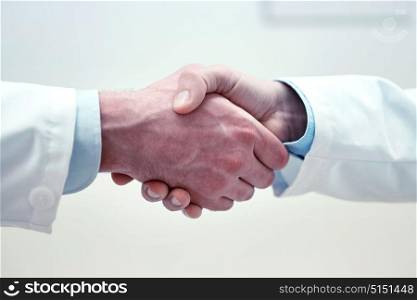 healthcare, profession, people and medicine concept - close up of doctors hands making handshake. close up of doctors hands making handshake