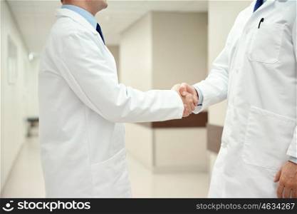 healthcare, profession, people and medicine concept - close up of doctors making handshake