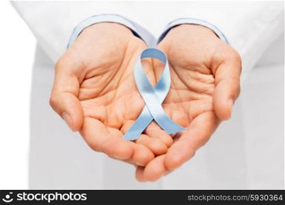 healthcare, profession, people and medicine concept - close up of male doctor hands holding sky blue prostate cancer awareness ribbon