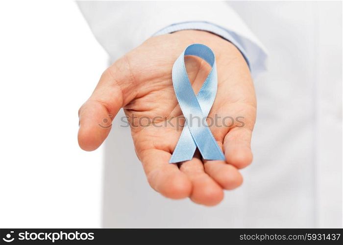 healthcare, profession, people and medicine concept - close up of male doctor hand holding sky blue prostate cancer awareness ribbon