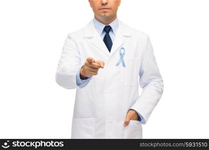 healthcare, profession, people and medicine concept - close up of male doctor in white coat with sky blue prostate cancer awareness ribbon pointing finger to you