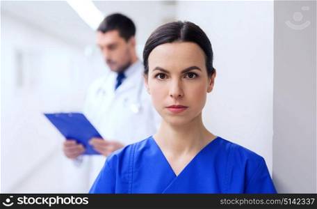 healthcare, profession, people and medicine concept - doctor or nurse at hospital corridor. doctor or nurse at hospital corridor