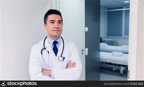 healthcare, profession, people and medicine concept - male doctor in white coat with stethoscope at hospital. doctor in white coat at hospital