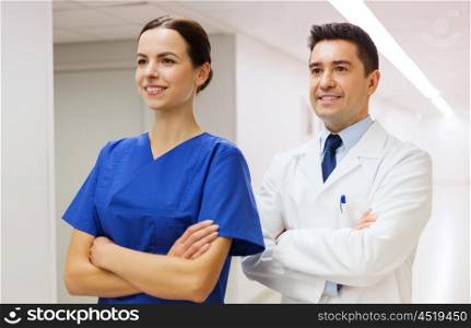 healthcare, profession, people and medicine concept - smiling doctor in white coat and nurse at hospital