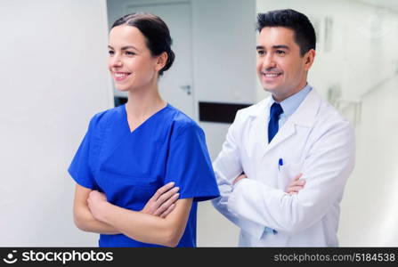 healthcare, profession, people and medicine concept - smiling doctor in white coat and nurse at hospital. smiling doctor in white coat and nurse at hospital