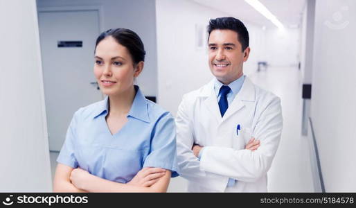 healthcare, profession, people and medicine concept - smiling doctor in white coat and nurse at hospital. smiling doctor in white coat and nurse at hospital