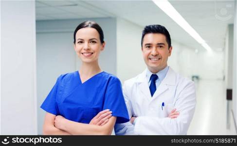 healthcare, profession, people and medicine concept - smiling doctor in white coat and nurse at hospital. smiling doctor in white coat and nurse at hospital