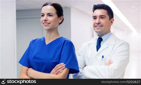 healthcare, profession, people and medicine concept - smiling doctor in white coat and nurse at hospital. smiling doctor in white coat and nurse at hospital