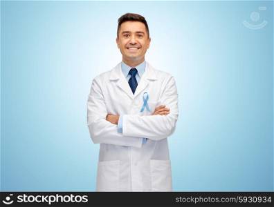healthcare, profession, people and medicine concept - smiling male doctor in white coat with sky blue prostate cancer awareness ribbon