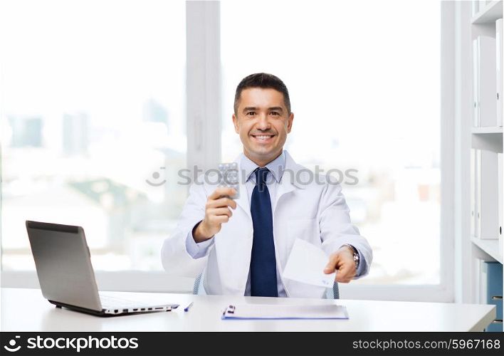 healthcare, profession, people and medicine concept - smiling male doctor in white coat with tablets and laptop computer in medical office