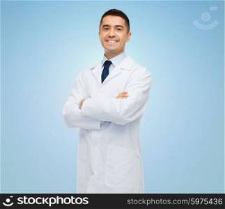 healthcare, profession, people and medicine concept - smiling male doctor in white coat over blue background