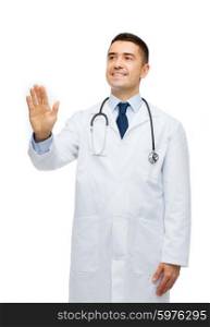 healthcare, profession, people and medicine concept - smiling male doctor in white coat touching something imaginary