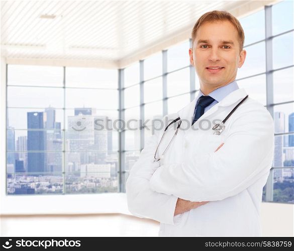 healthcare, profession, people and medicine concept - smiling male doctor with stethoscope in white coat over clinic background
