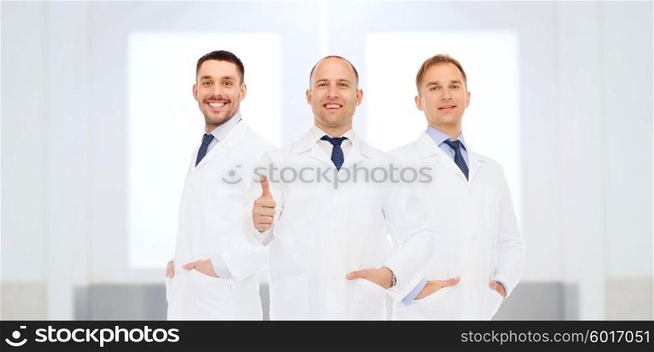 healthcare, profession, people, gesture and medicine concept - group of happy male doctors at hospital showing thumbs up