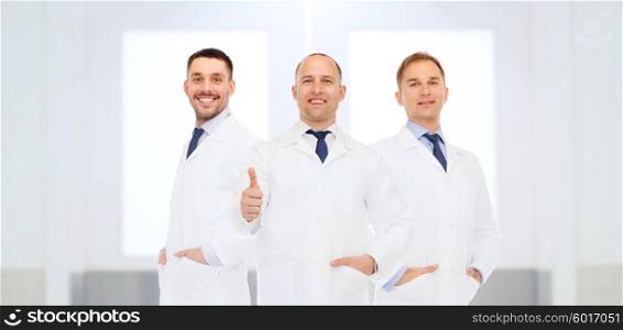 healthcare, profession, people, gesture and medicine concept - group of happy male doctors at hospital showing thumbs up