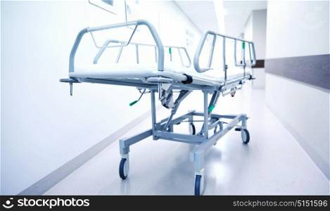 healthcare, reanimation, emergency room and medicine concept - gurney or wheeled stretcher at hospital corridor. hospital gurney or stretcher at emergency room