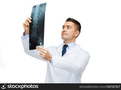 healthcare, rontgen, people and medicine concept - male doctor in white coat looking at x-ray