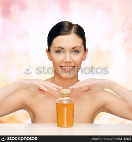 healthcare, spa and beauty concept - beautiful woman with oil bottle