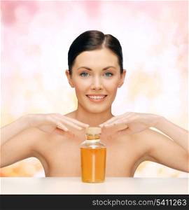 healthcare, spa and beauty concept - beautiful woman with oil bottle