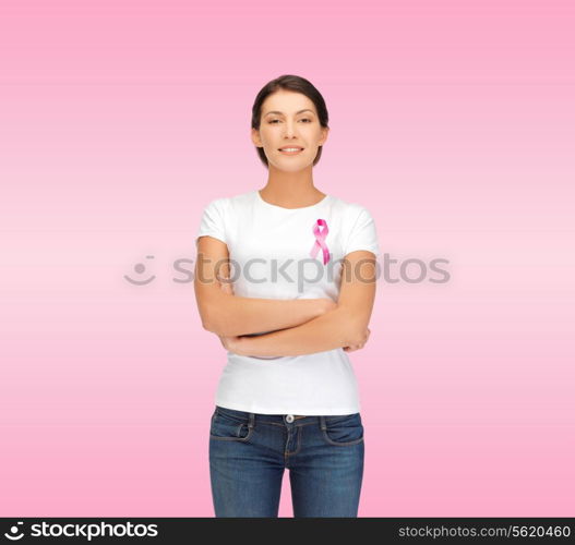 healthcare, support, people and medicine concept - smiling woman in blank white t-shirt with breast cancer awareness ribbon over pink background