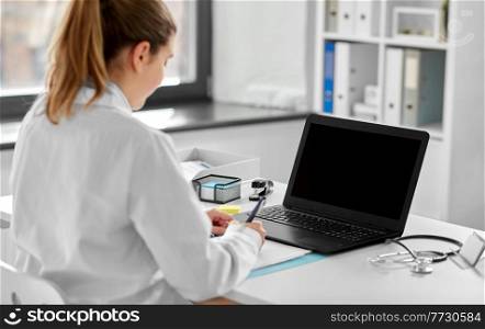 healthcare, technology and medicine concept - female doctor in white coat with laptop computer working at hospital. female doctor with laptop at hospital