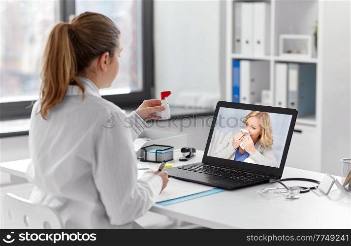 healthcare, technology and medicine concept - female doctor with laptop computer having video call with middle aged patient and showing oral spray at hospital. doctor with laptop having video call with patient