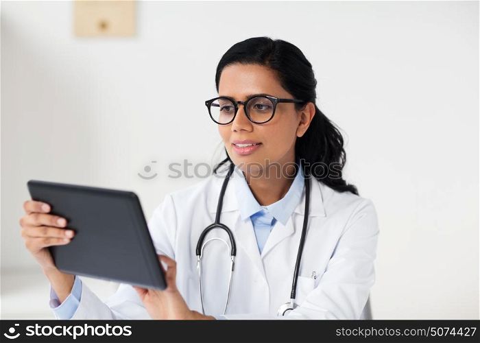 healthcare, technology, people and medicine concept - female doctor in glasses with tablet pc computer in medical office at hospital. female doctor with tablet pc at hospital