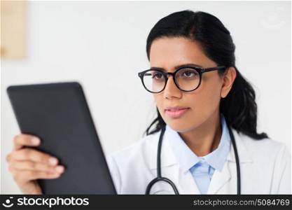 healthcare, technology, people and medicine concept - female doctor in glasses with tablet pc computer at hospital. female doctor with tablet pc at hospital. female doctor with tablet pc at hospital