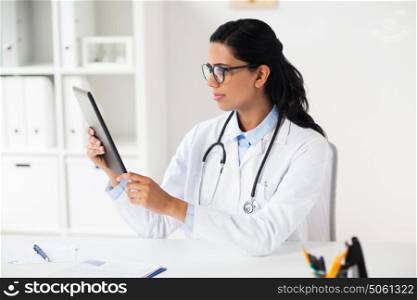 healthcare, technology people and medicine concept - female doctor in white coat with tablet pc computer and clipboard at hospital. doctor with tablet pc and clipboard at hospital