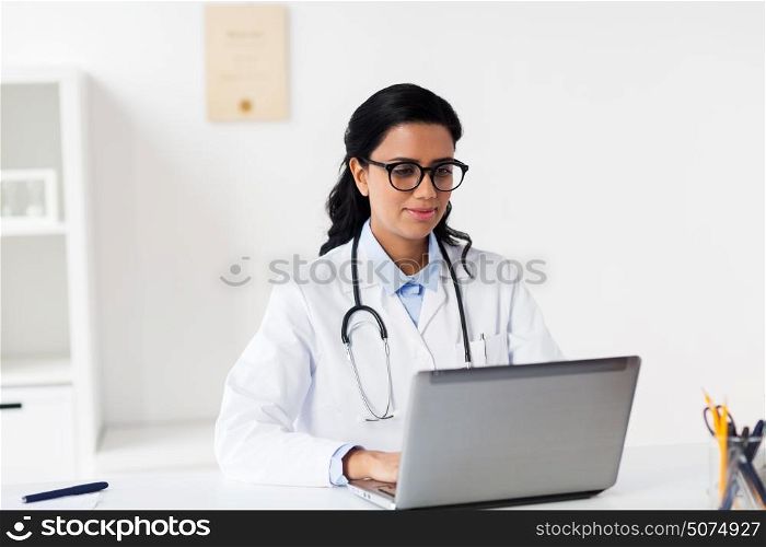 healthcare, technology people and medicine concept - female doctor in white coat with laptop computer at hospital. female doctor with laptop at hospital
