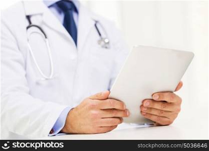 healthcare, technology, profession, people and medicine concept - male doctor in white coat with tablet pc computer at hospital. male doctor in white coat with tablet pc