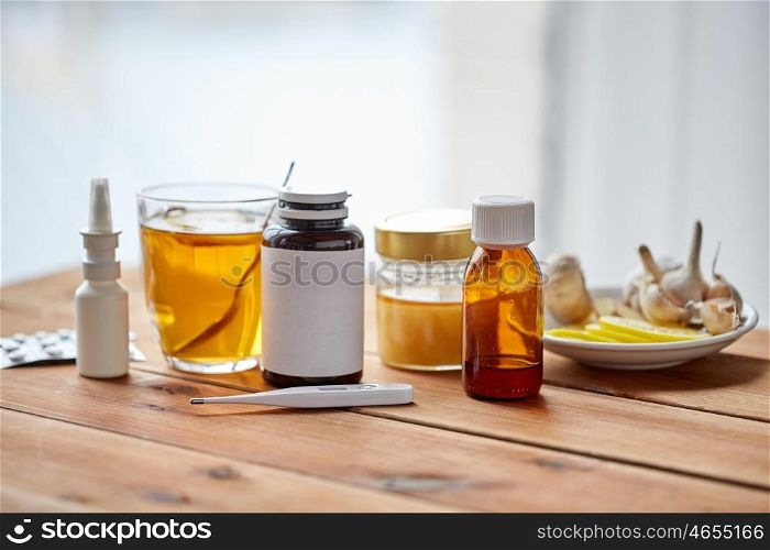 healthcare, traditional medicine, flu and ethnoscience concept - drugs on wooden table