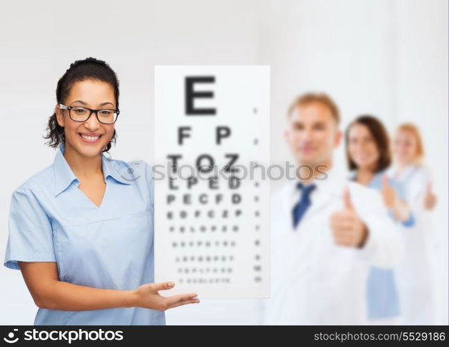 healthcare, vision and medicine concept - smiling female african american doctor or nurse in eyeglasses with small white blank board