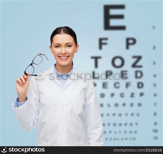 healthcare, vision and medicine concept - smiling female doctor with glasses and eye chart