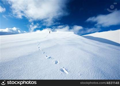 Healthy active girl traveling along high snowy mountains, beautiful natural landscape, blue sky, winter time holidays&#xA;