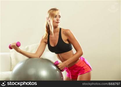 Healthy active lifestyle. Fitness woman with gym ball and dumbbell doing exercise