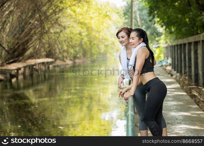 Healthy adult Asian women outdoors jogging or running in the morning countryside green fresh nature background.