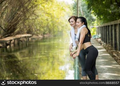 Healthy adult Asian women outdoors jogging or running in the morning countryside green fresh nature background.