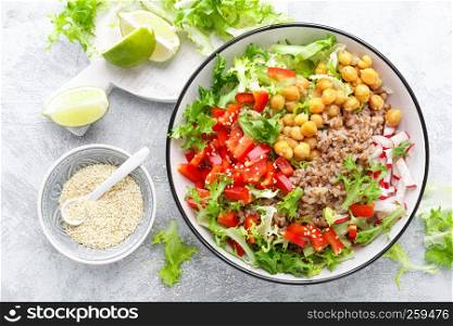 Healthy and delicious bowl with buckwheat and salad of chickpea, fresh pepper and lettuce leaves. Dietary balanced plant-based food. Vegan and vegetarian dish. Top view. Flat lay