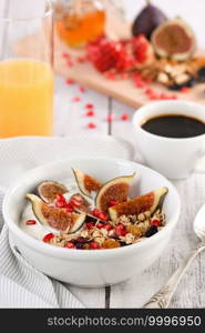 Healthy and delicious breakfast. Oatmeal muesli with Greek yogurt, fresh figs, dried fruits and pomegranate.