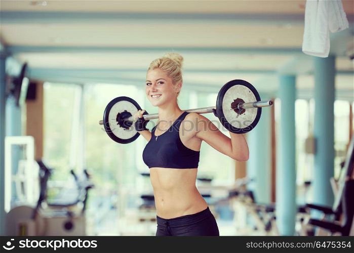 healthy and fit young woman in fitness gym lifting weights and working on her butt muscles. young woman in fitness gym lifting weights