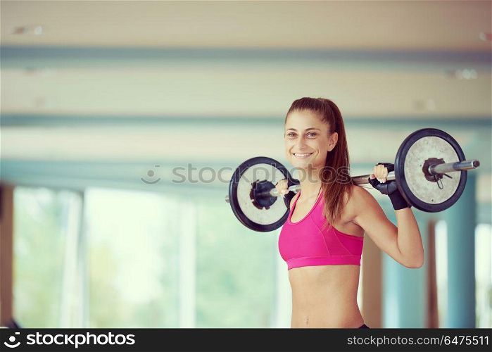 healthy and fit young woman in fitness gym lifting weights and working on her butt muscles. young woman in fitness gym lifting weights
