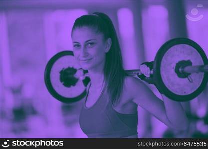 healthy and fit young woman in fitness gym lifting weights and working on her butt muscles duo tone. young woman in fitness gym lifting weights