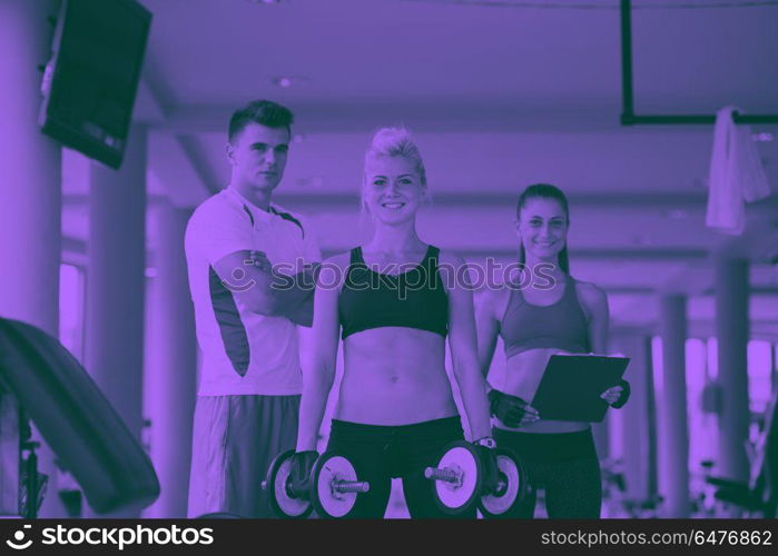 healthy and fit young woman in fitness gym lifting weights and working on her butt muscles duo tone. young woman in fitness gym lifting weights