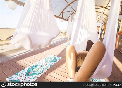 Healthy and fly Yoga Concept. happy girls are sitting in hammocks in a fly yoga class