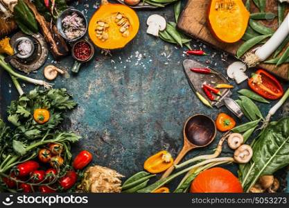 Healthy and organic harvest vegetables and ingredients: pumpkin, greens, tomatoes,kale,leek,chard,celery on rustic kitchen table background for tasty Thanksgiving seasonal cooking, frame, top view
