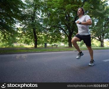 healthy athlete man jogging at morning on empty roat in the city
